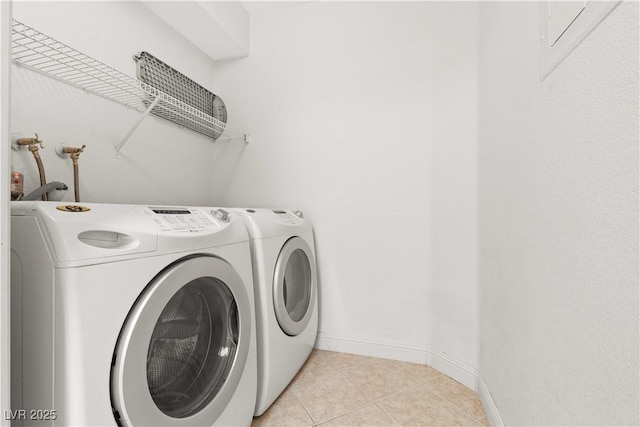 laundry area with washer and dryer and light tile patterned floors