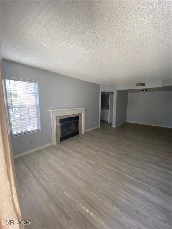 unfurnished living room with hardwood / wood-style floors and a textured ceiling