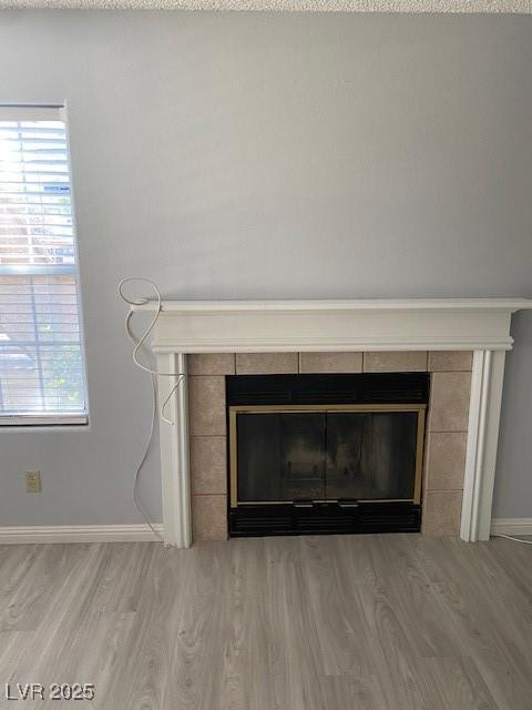 details with wood-type flooring and a tile fireplace