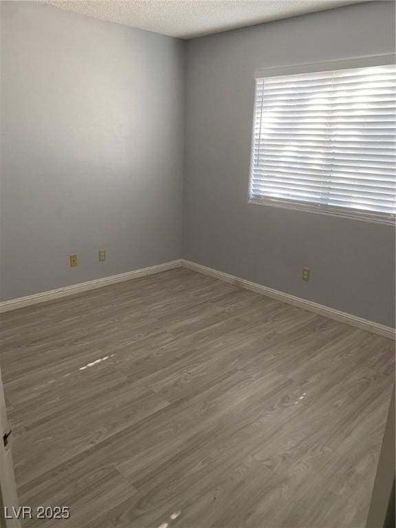 empty room with a textured ceiling and dark wood-type flooring