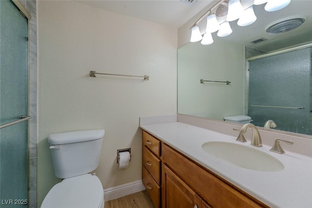 bathroom featuring vanity, hardwood / wood-style flooring, toilet, and walk in shower