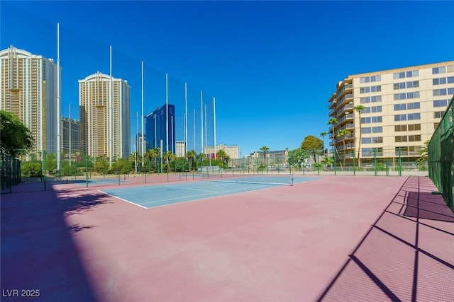 view of tennis court with basketball hoop