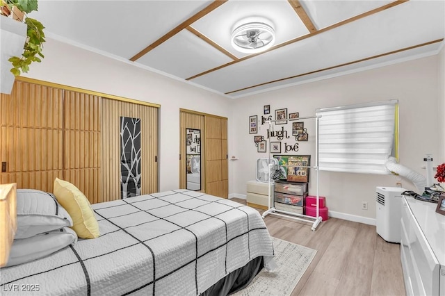 bedroom featuring light wood finished floors and baseboards