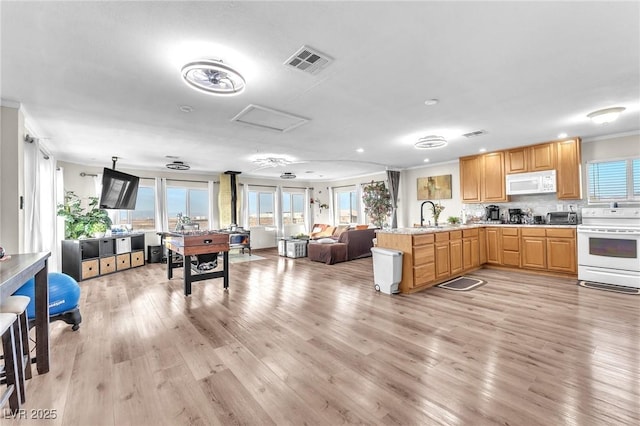 kitchen with white appliances, visible vents, light wood-style floors, open floor plan, and light countertops