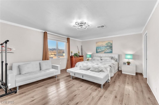 bedroom featuring ornamental molding, visible vents, baseboards, and wood finished floors