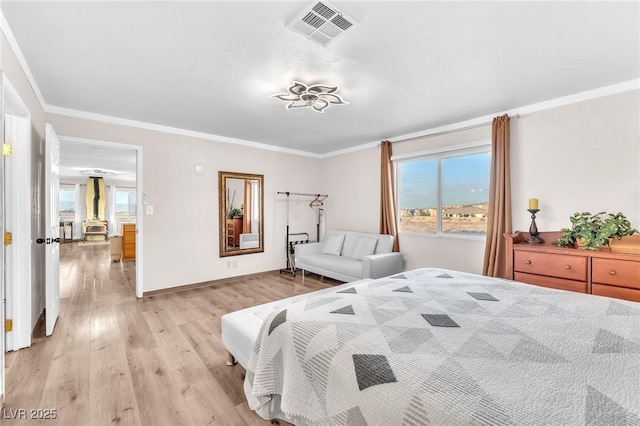 bedroom featuring baseboards, visible vents, crown molding, and light wood finished floors