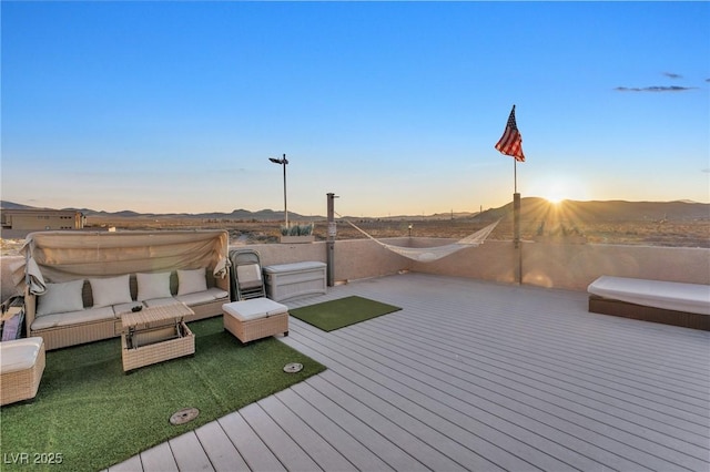 deck at dusk with a mountain view and an outdoor hangout area