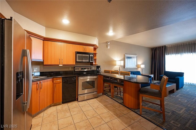 kitchen featuring kitchen peninsula, sink, light tile patterned floors, and stainless steel appliances