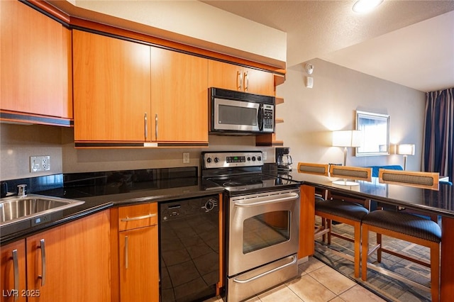 kitchen featuring light tile patterned flooring, sink, and appliances with stainless steel finishes