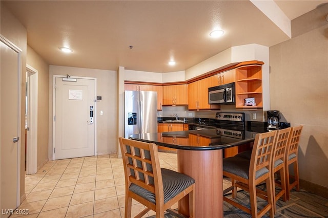 kitchen with sink, stainless steel appliances, kitchen peninsula, a breakfast bar, and light tile patterned floors