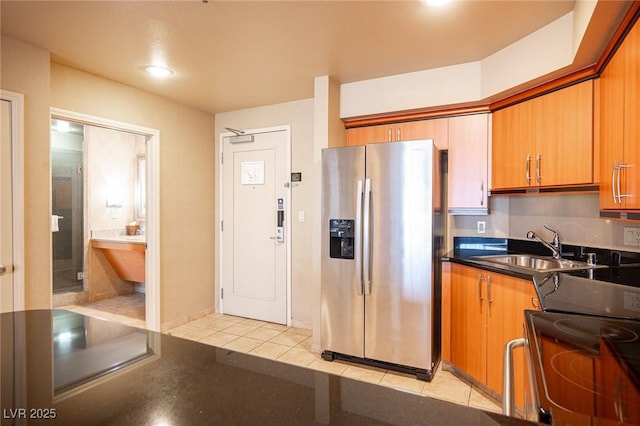 kitchen featuring stainless steel fridge, range, light tile patterned floors, and sink