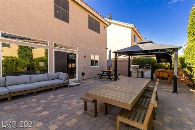 view of patio / terrace featuring a gazebo, grilling area, an outdoor living space, and exterior kitchen