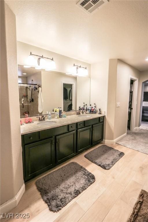 bathroom with a shower with door and vanity