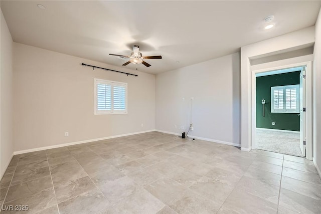 unfurnished room featuring ceiling fan and a healthy amount of sunlight