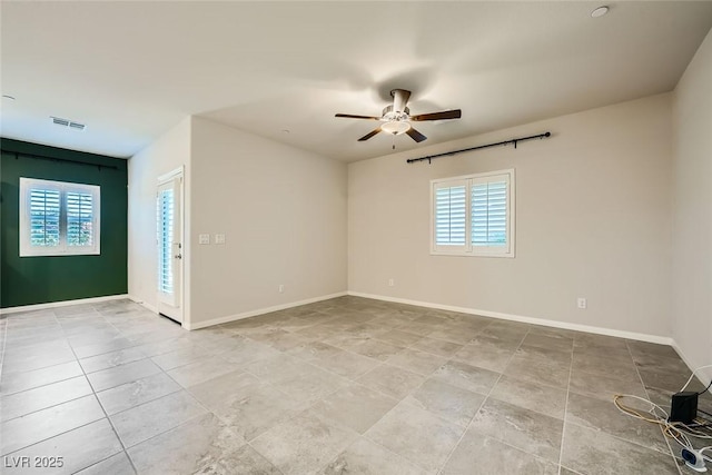 empty room featuring ceiling fan and a healthy amount of sunlight