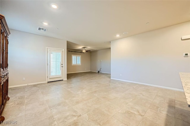 empty room with ceiling fan and a stone fireplace