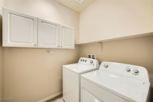 clothes washing area with cabinets and washing machine and clothes dryer