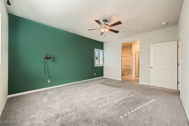 unfurnished bedroom with ceiling fan, a closet, a spacious closet, and carpet floors