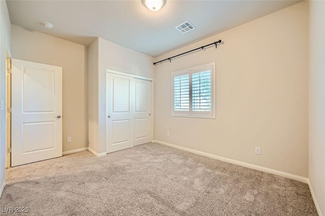 unfurnished bedroom with a closet and light carpet