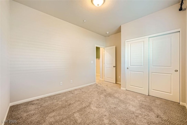 unfurnished bedroom featuring light carpet and a closet