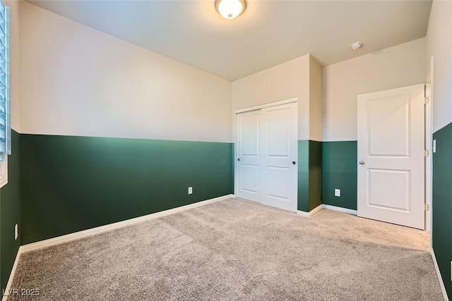 unfurnished bedroom with a closet, lofted ceiling, and carpet floors