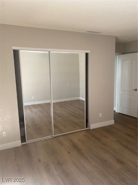 unfurnished bedroom with dark wood-type flooring