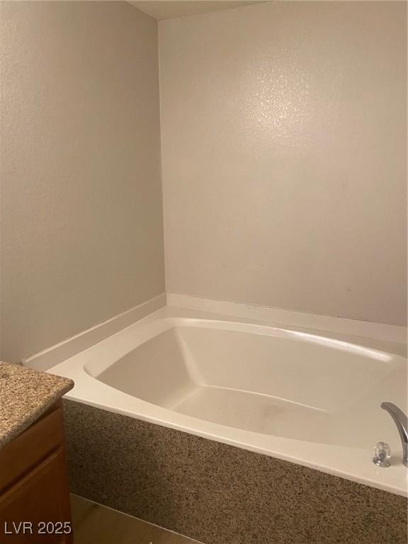 bathroom with a bathing tub and vanity