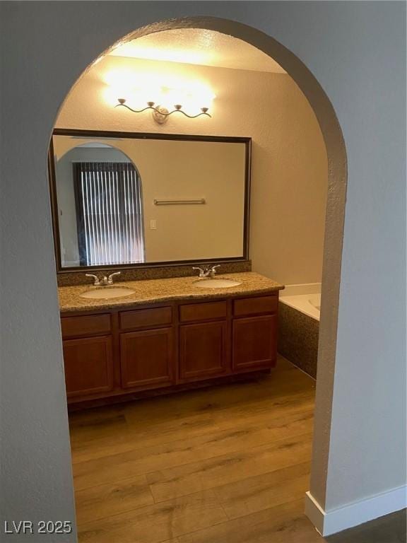 bathroom featuring vanity, hardwood / wood-style flooring, and a bathing tub