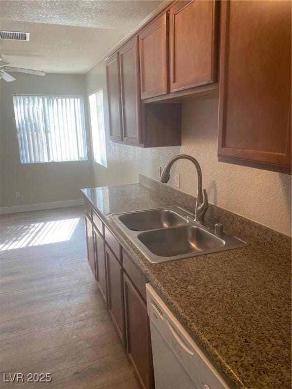 kitchen with dishwasher, sink, ceiling fan, and light hardwood / wood-style floors