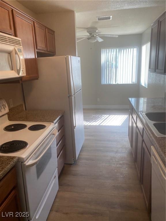 kitchen with wood-type flooring, white appliances, ceiling fan, and sink