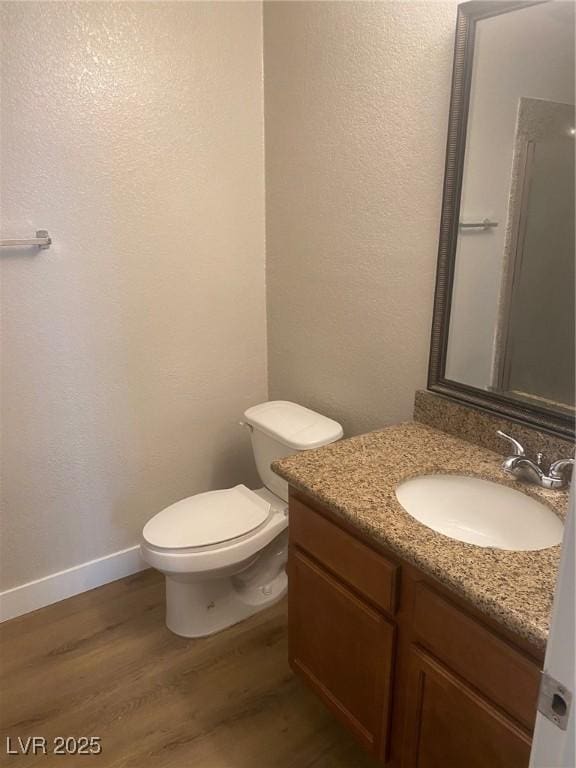 bathroom featuring hardwood / wood-style floors, vanity, toilet, and an enclosed shower