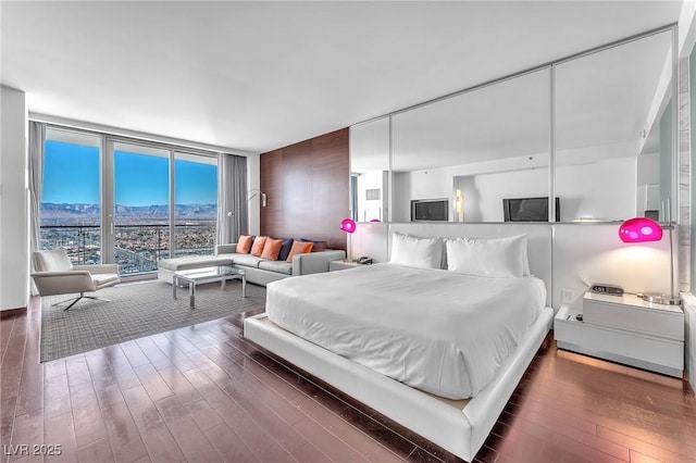 bedroom featuring floor to ceiling windows and dark wood-type flooring