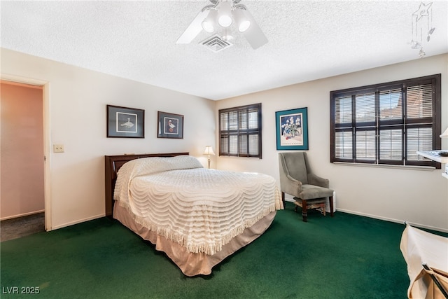 bedroom with ceiling fan, dark carpet, and a textured ceiling