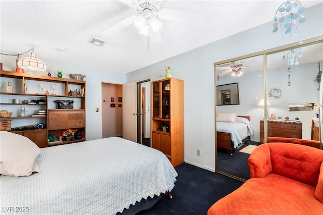 carpeted bedroom with ceiling fan, a closet, and a textured ceiling