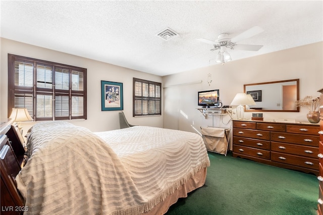 carpeted bedroom featuring ceiling fan and a textured ceiling