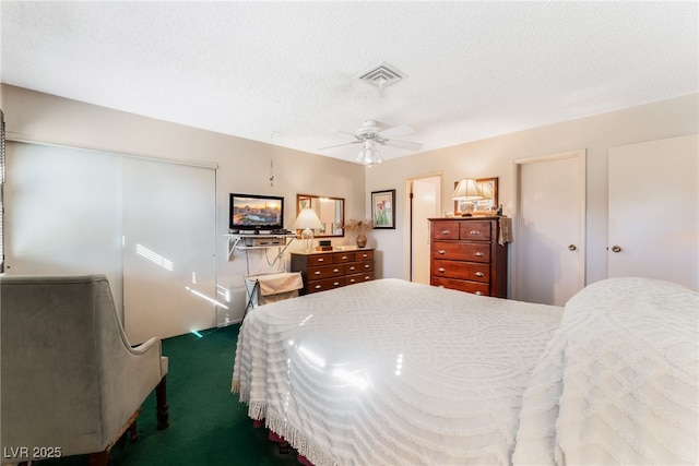 carpeted bedroom featuring ceiling fan and a textured ceiling