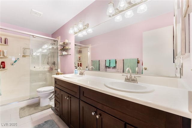 bathroom featuring tile patterned floors, vanity, toilet, and a shower with shower door