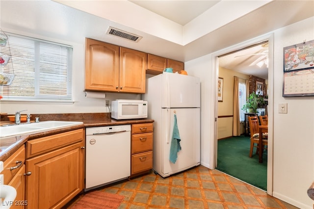 kitchen featuring light carpet, white appliances, and sink