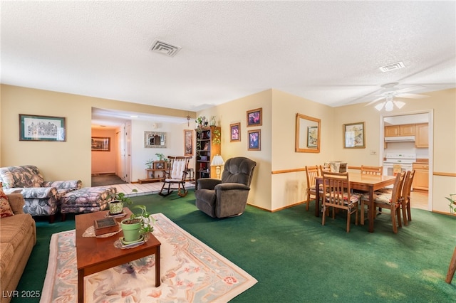 carpeted living room with ceiling fan and a textured ceiling