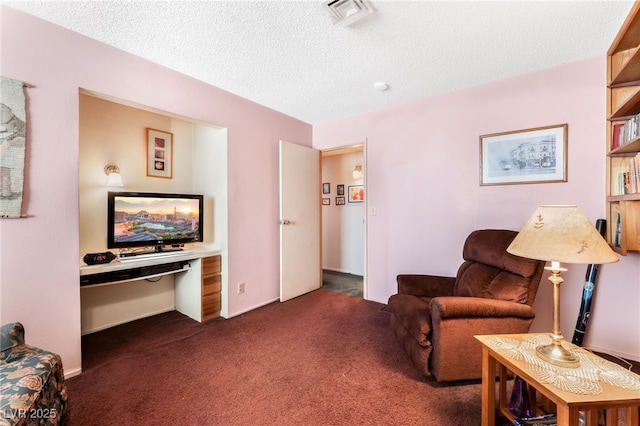 sitting room with dark colored carpet and a textured ceiling