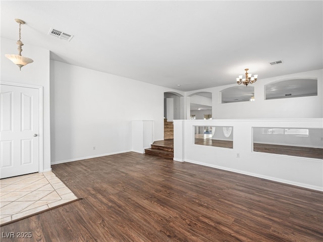 unfurnished living room with dark hardwood / wood-style flooring and a chandelier