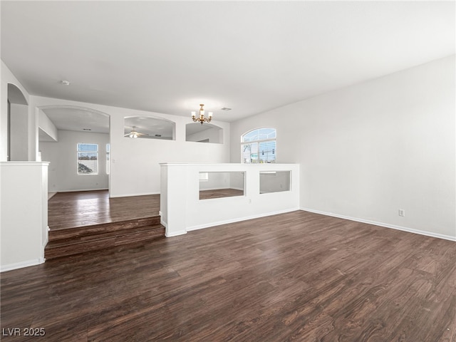 unfurnished living room featuring dark hardwood / wood-style floors and a notable chandelier