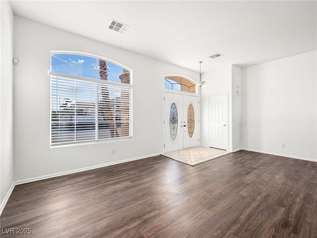 entrance foyer with dark hardwood / wood-style flooring, a wealth of natural light, and french doors