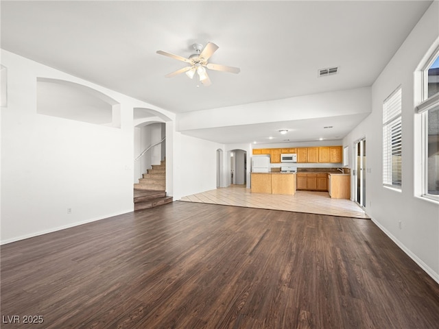 unfurnished living room with ceiling fan, sink, and light wood-type flooring