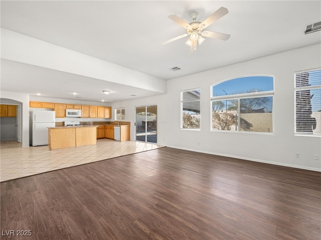 unfurnished living room with ceiling fan and light wood-type flooring