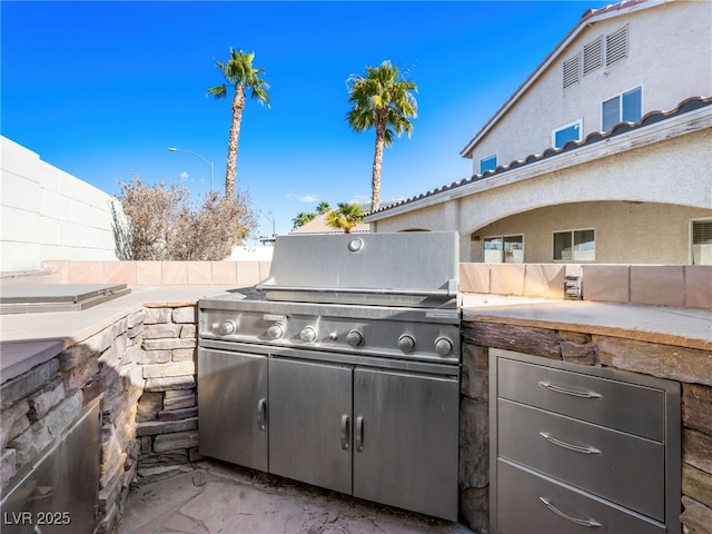 view of patio featuring an outdoor kitchen and a grill