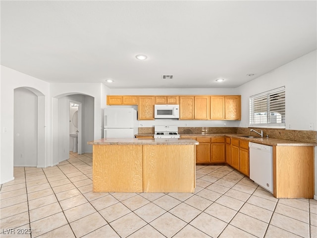 kitchen featuring light tile patterned flooring, white appliances, a kitchen island, and sink