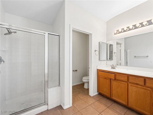 bathroom featuring tile patterned flooring, vanity, toilet, and a shower with shower door