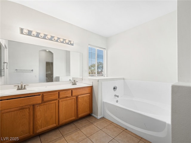 bathroom featuring tile patterned flooring, a bath, and vanity