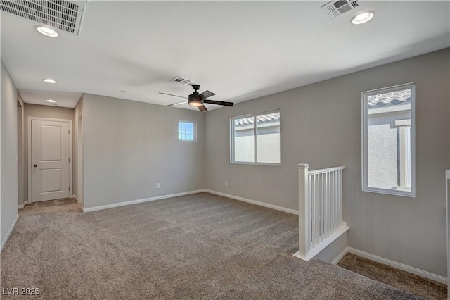 carpeted spare room featuring ceiling fan